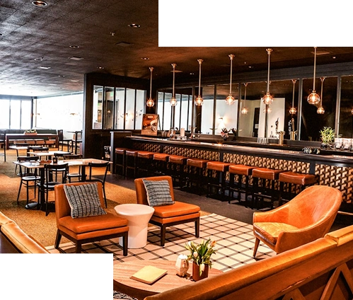 Şık restoran salonu iç mekanı, sıcak aydınlatması, bar oturma düzeni ve modern mobilya düzenlemesiyle dikkat çekiyor.